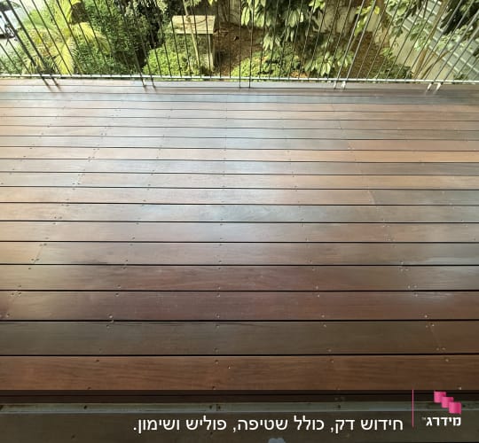 דק עץ חום עם מעקה מתכת בגינה